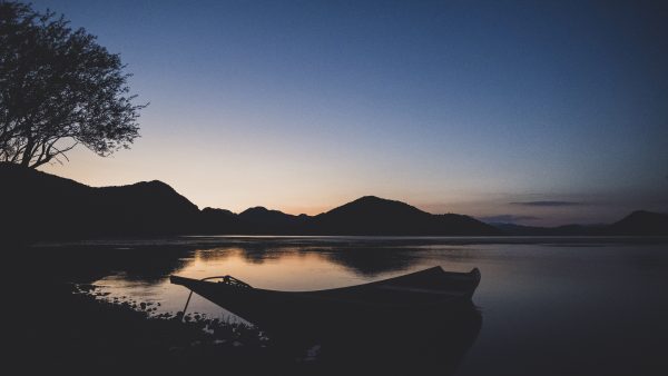 • Lake Skadar photography, twilight boat silhouette, serene landscapes, minimalist fine art, Albanian lake sunset, tranquil nature photography, evening light on water, silhouette art photography, reflective waterscape, fine art limited edition, peaceful dusk photography, ethereal lake view, nature-inspired art, meditative landscapes, calmness and reflection